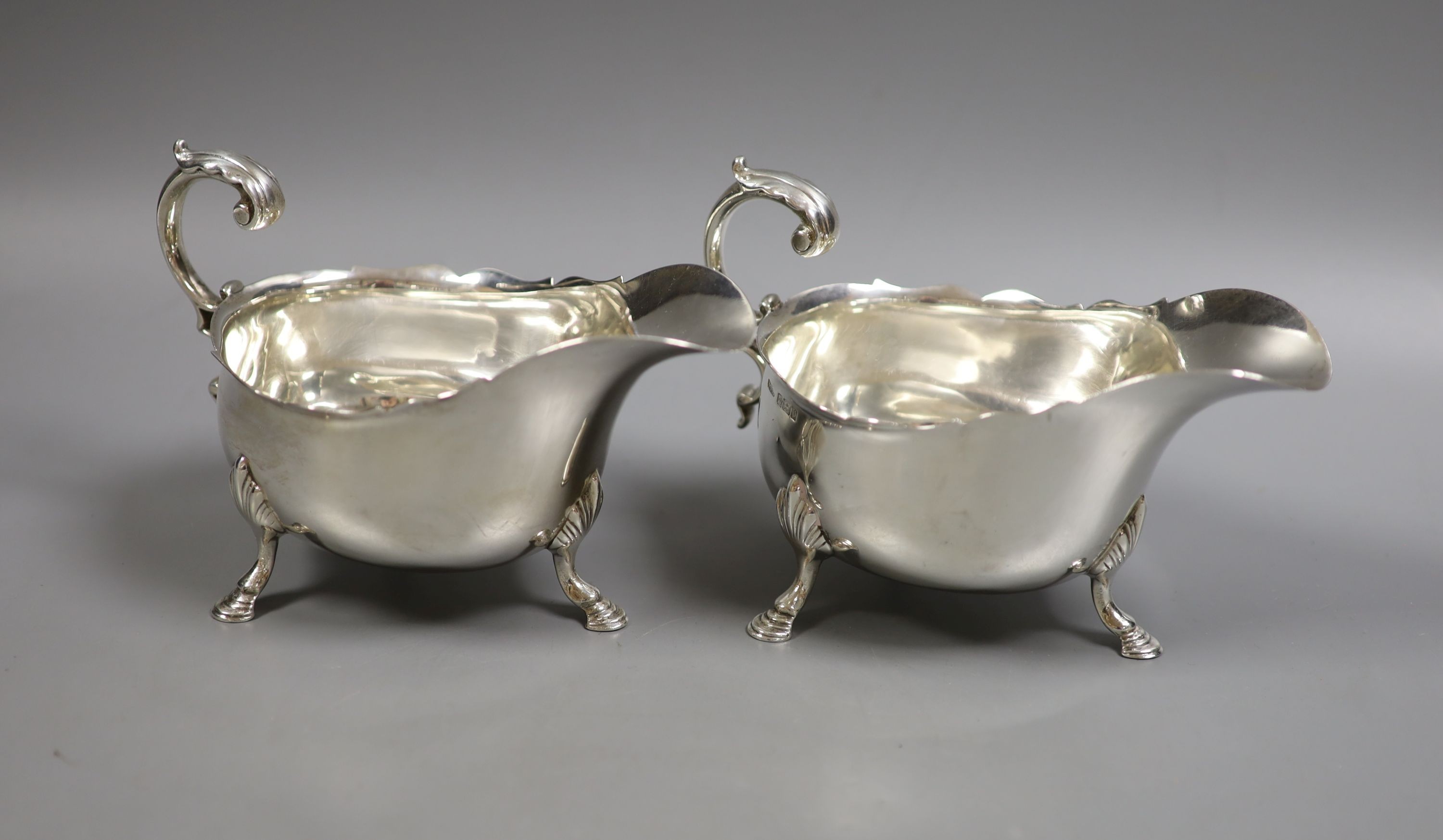 A pair of Edwardian silver sauceboats, with flying scroll handles, Henry Stratford Ltd, Sheffield, 1905/7, height 10.5cm, 17oz.